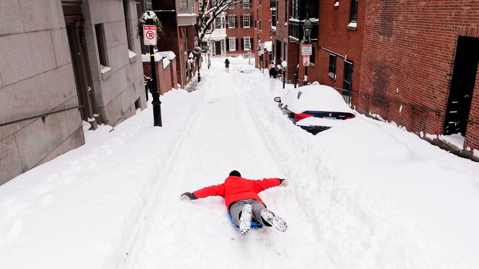 Ian Flood sleds down a street in his Beacon Hill neighborhood following a winter storm that dump more than a foot of snow across the region, Monday, Jan. 26, 2026, in Boston. (AP Photo/Charles Krupa)