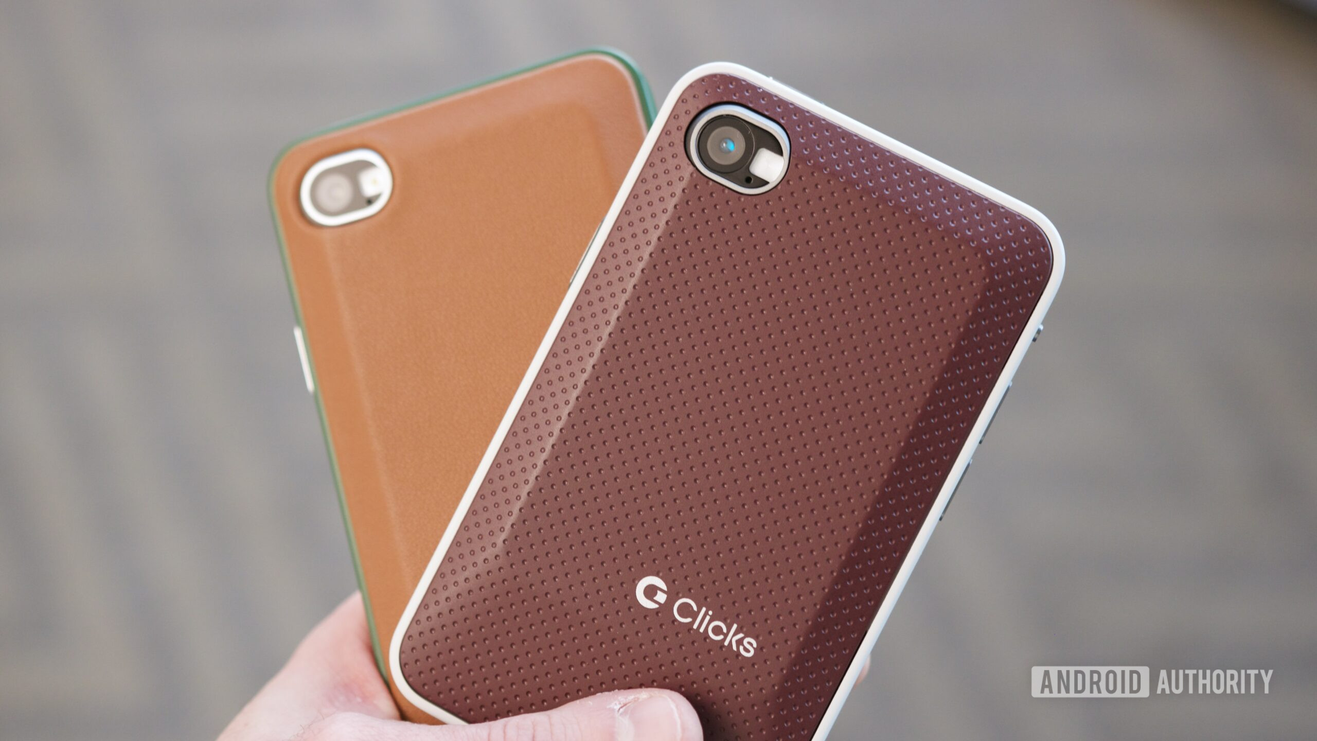 Someone holding two Clicks Communicator phones.