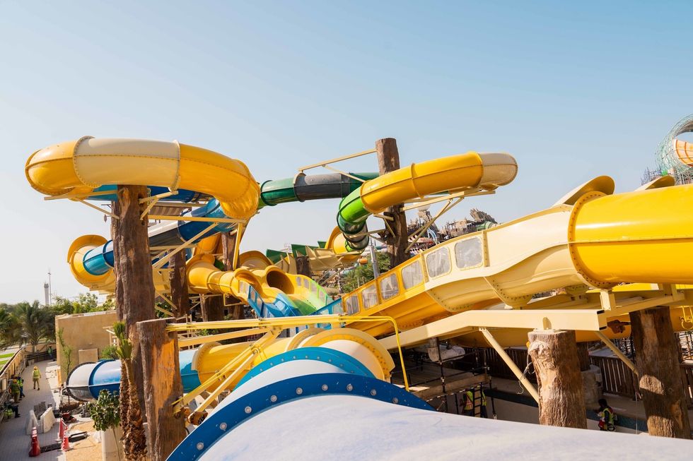 Colorful intertwined water slides at Yas Waterworld under a clear sky.