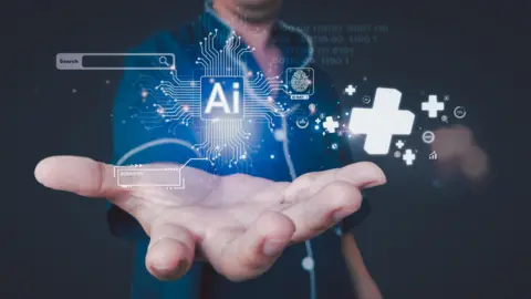Getty Images A nurse holds out her hand which is centre frame and above it are computerised AI images. The hand is prominent in the picture with computer fibre patterns. The nurse is anonymous and you can't see her head, but you can see her blue uniform.