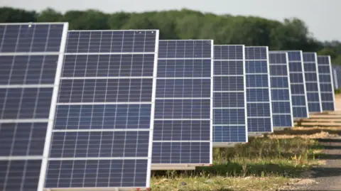 Getty Images Rows of solar panels in a field forming a solar panel.