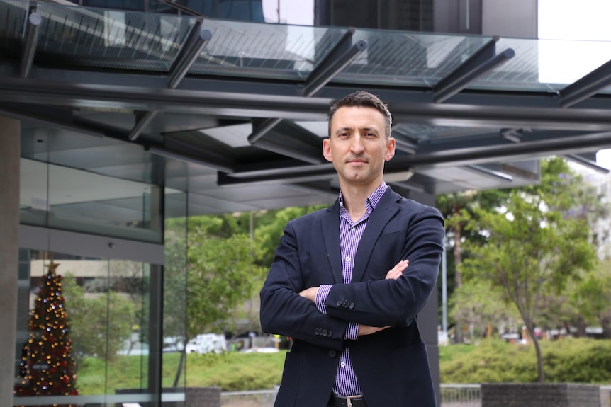 Mr Morey stands with his arms folded.