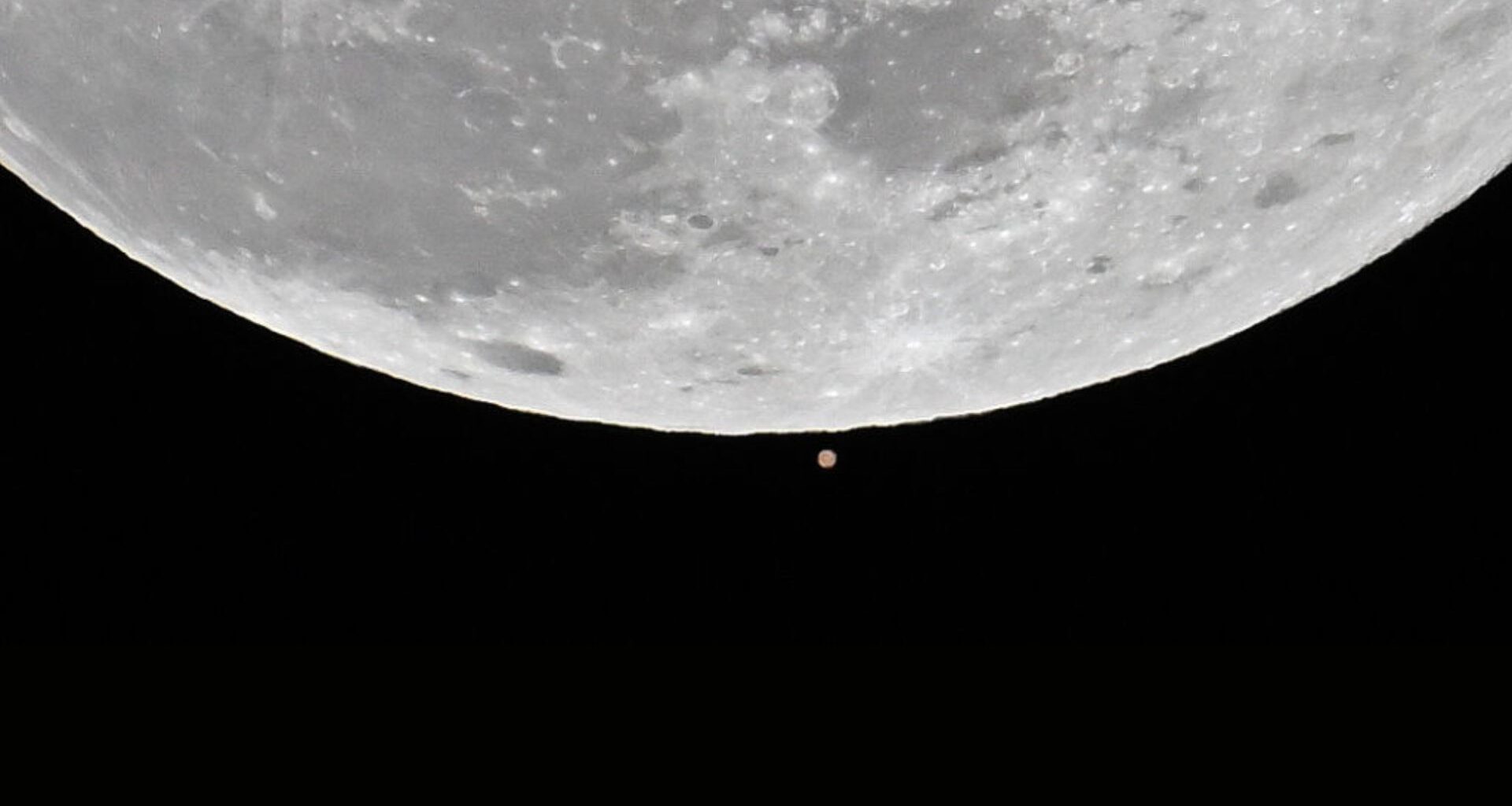 The first full moon of the 2025 called 'Wolf Moon' that seen next to Mars rises over the sky during a lunar occultation of Mars in Charlotte, United States on January 13, 2025.