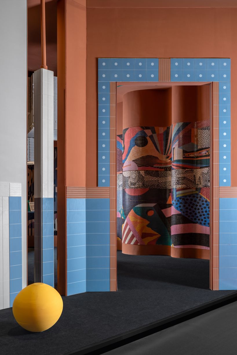 patterned tiles extend from curved walls to furniture in layered retail exhibition booth