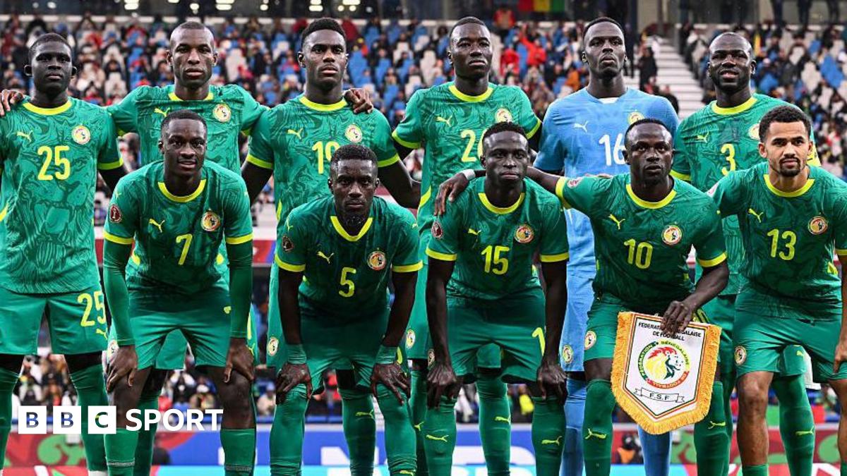 Senegal players wearing green shirts, shorts and socks pose for a team photo