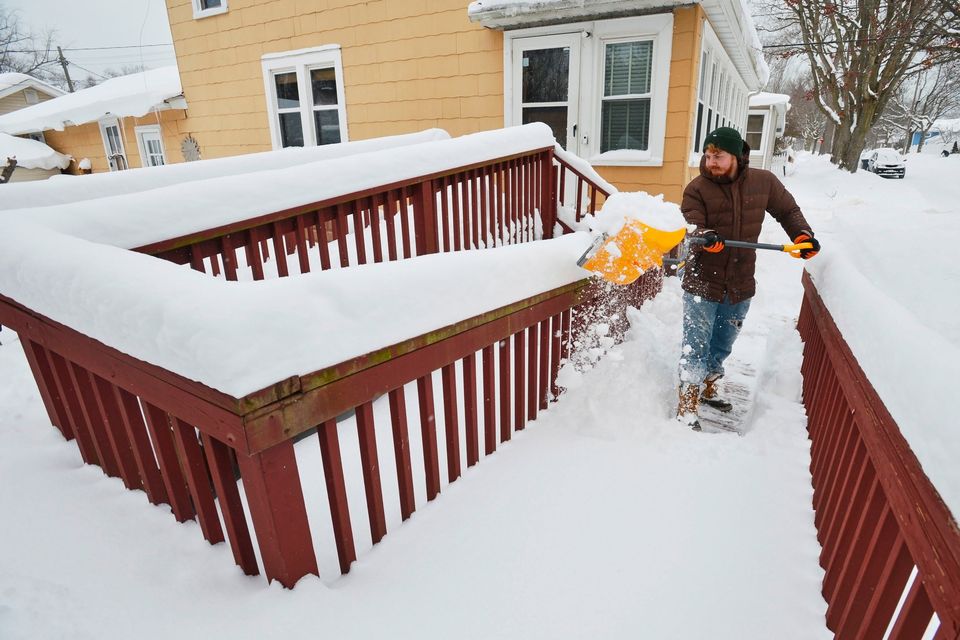 Charlie Johan clears snow on a handicap ramp at a home along Park Street in St. Joseph, Mich., Monday, Jan. 26, 2026, after a winter storm dumped several inches of snow. (Don Campbell/The Herald-Palladium via AP)
