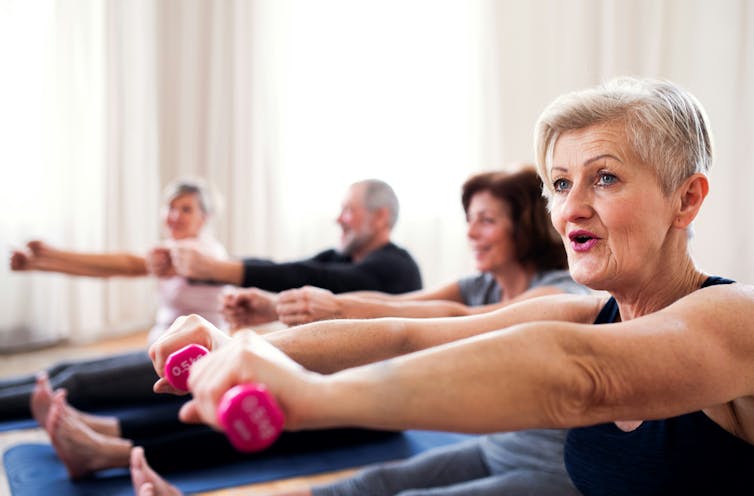 Adults using small dumbbells in an exercise class