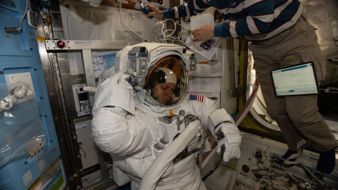 Dec. 30, 2025: NASA astronaut and Expedition 74 Flight Engineer Zena Cardman is pictured in her pressurized spacesuit, checking its communication and power systems ahead of a spacewalk planned for Thursday, Jan. 8, 2025. At upper right, JAXA (Japan Aerospace Exploration Agency) astronaut and Flight Engineer Kimiya Yui assists Cardman as she tests the operations of her spacesuit inside the International Space Station’s Quest airlock.