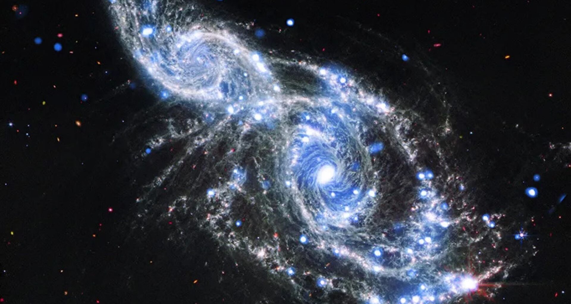 Two blue and white spirals of light are intertwined in the darkness of space