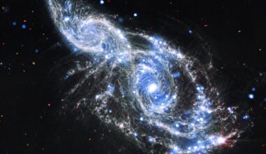 Two blue and white spirals of light are intertwined in the darkness of space