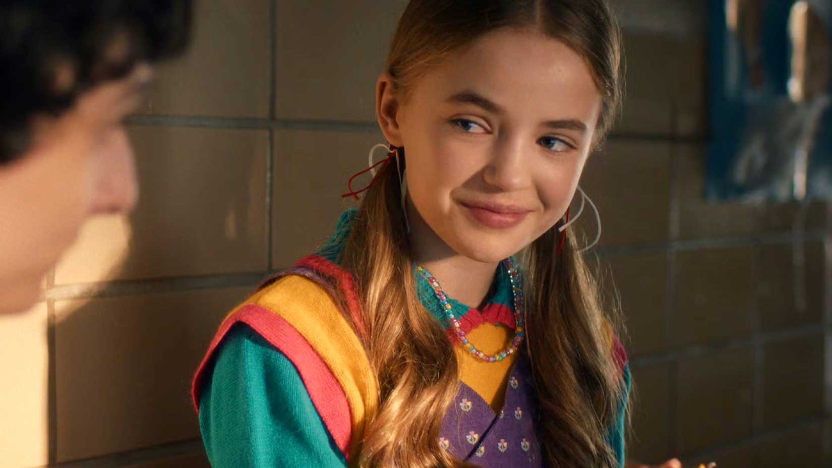 Nell Fisher as Holly Wheeler smiling in Stranger Things season 5