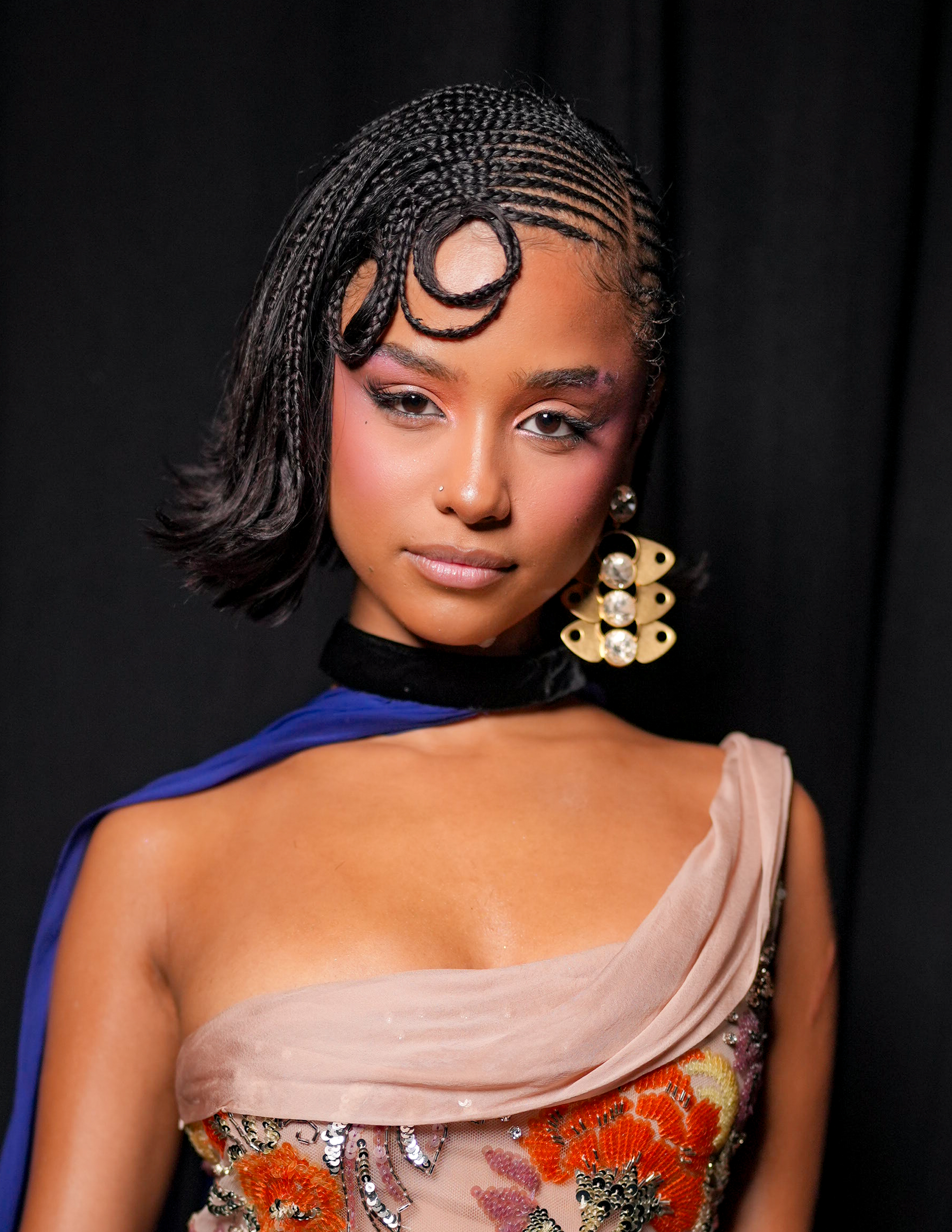 a black woman with short, braided hair photographed at a fashion show