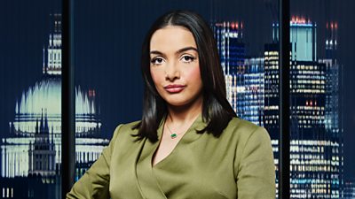 A woman in a green suit poses outside a city landscape 