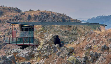 glass mirrors the andean terrain across cabin by rtresarquitectos