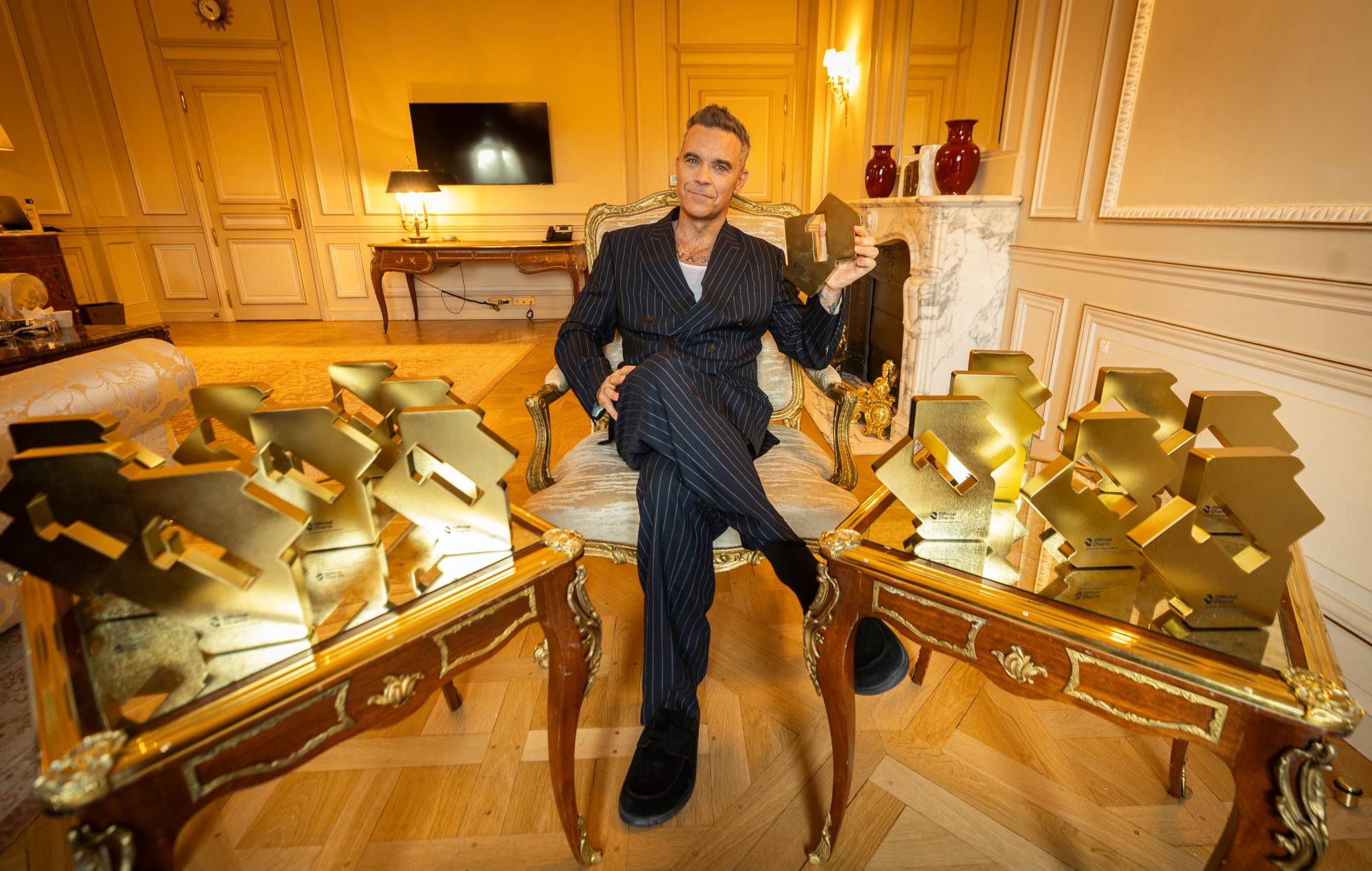 Robbie Williams celebrates scoring a record-breaking run of Number One albums in the UK. Credit: Press/Robbie Williams