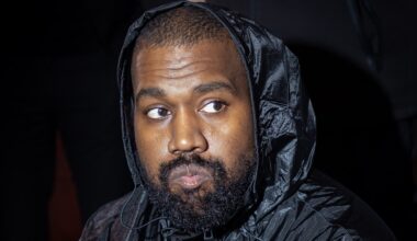 Kanye West wearing a black hooded jacket.