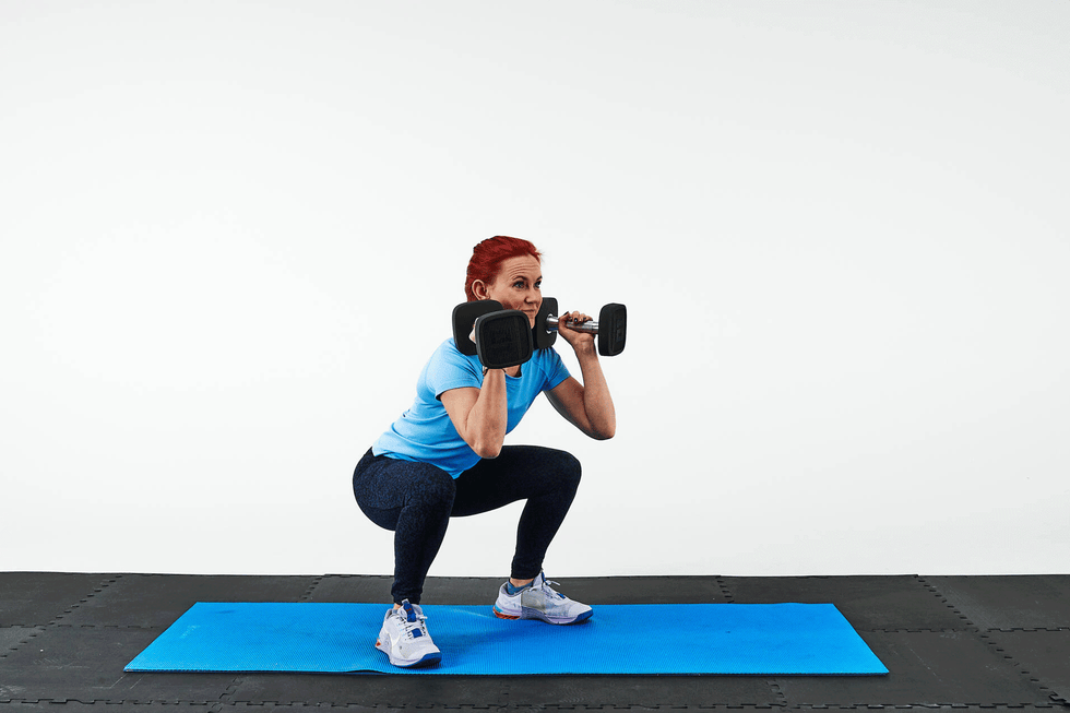 person performing a squat exercise with dumbbells