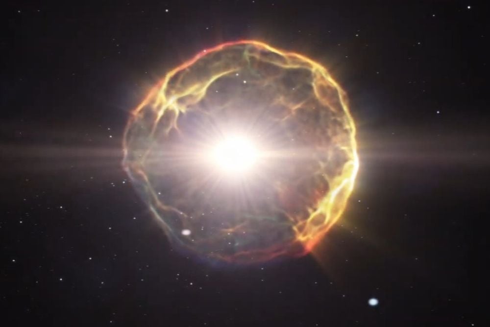 This screenshot shows an artist's illustration of a supernova explosion. Astronomers detected a pair of ancient supernova that are being gravitationally lensed by galaxy clusters. The pair of exploding stars could help cosmologists solve the Hubble Tension and determine the value of the Hubble Constant, the rate of expansion of the Universe. Image Credit: ESA/Hubble (L. Calçada)