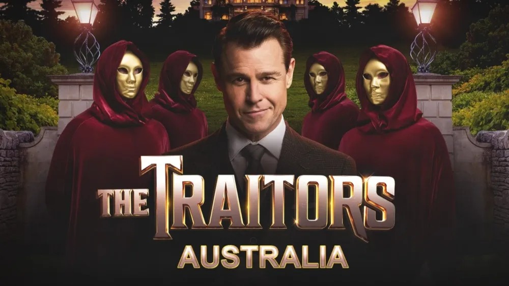 Host Rodger Corser stands in front of a manor at dusk, flanked by four figures in red hooded cloaks wearing gold masks.