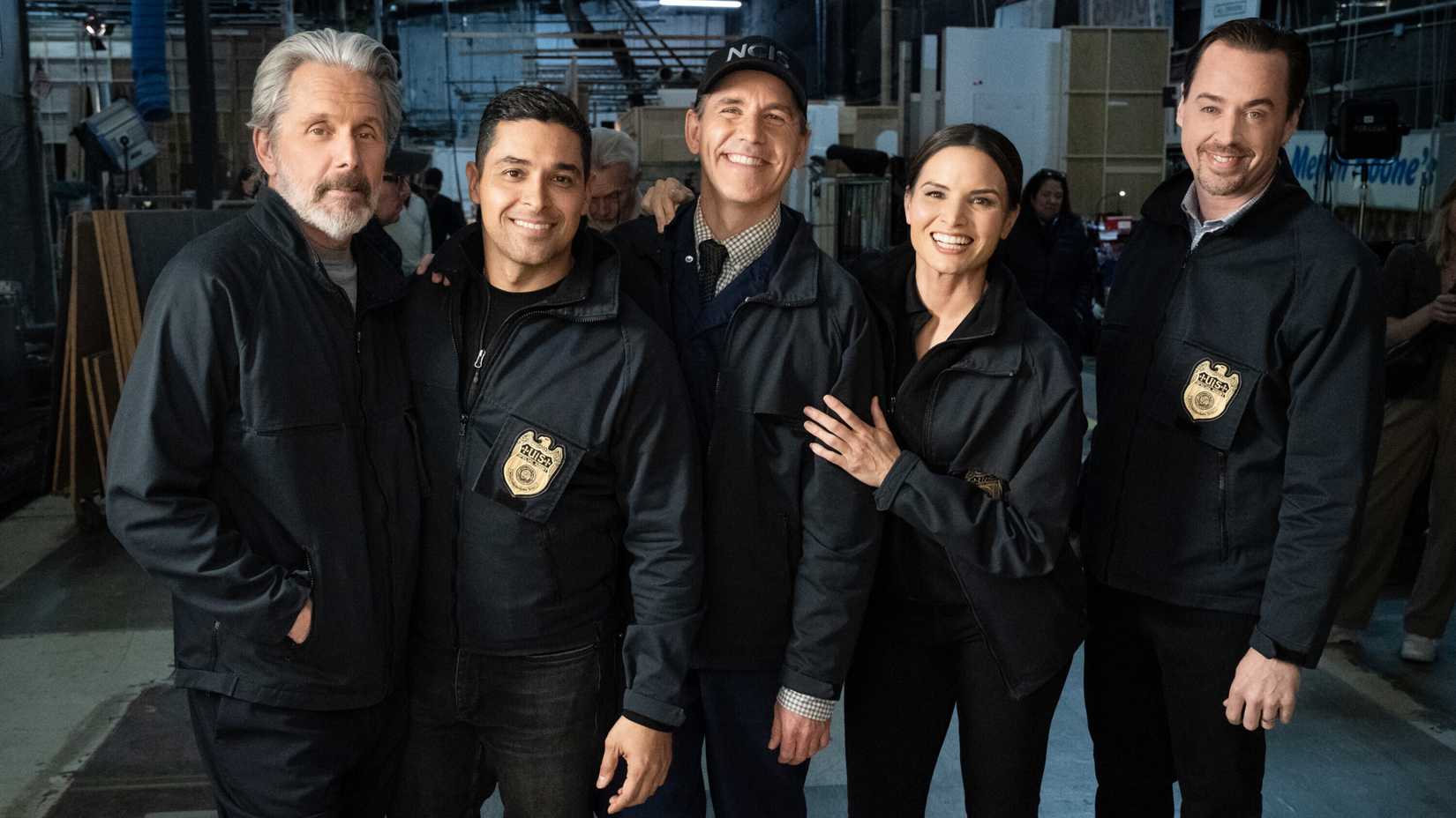 The cast of NCIS smiling in a photo from behind the scenes