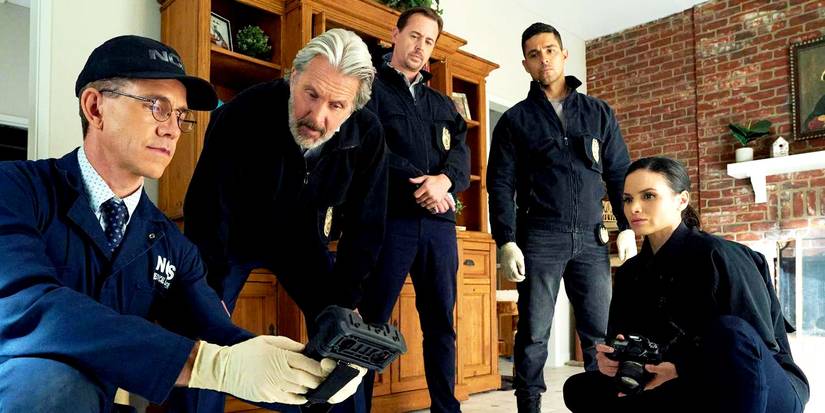 Torres, McGee, Jessica, and Dr. Palmer are in the room together looking a data pad in NCIS