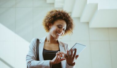 An investor looks at something on a smartphone in a modern building.