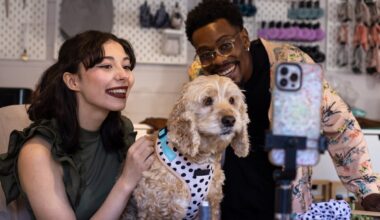 Two people taking a selfie with a dog.