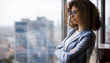 An investor gazes out the window in a city.
