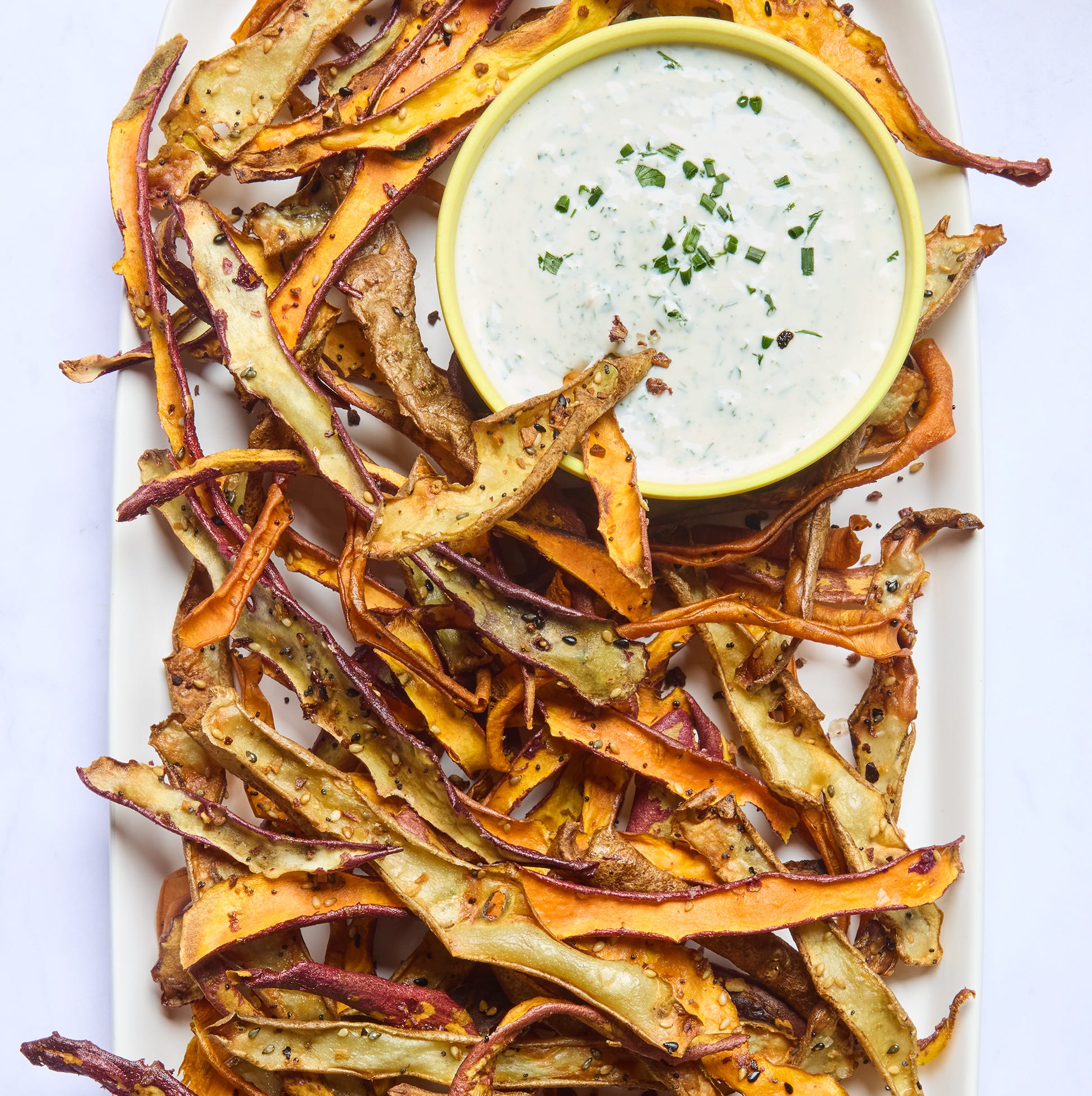 roasted veggie peels on a platter served with a creamy dip