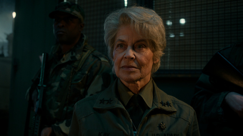 Dr. Kay flanked by soldiers in 