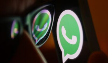 WhatsApp logo reflected on sunglasses and displayed on a phone screen.