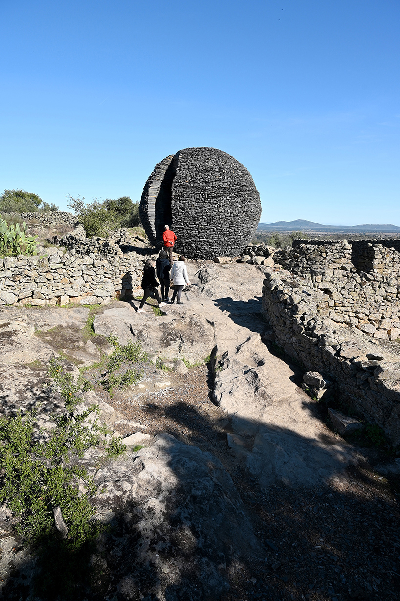 atelier yokyok sculpts sphere land installation out of black schist and granite in portugal