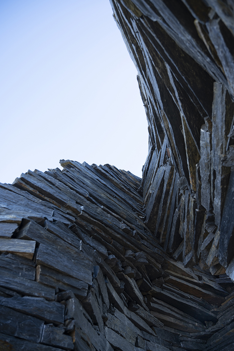 atelier yokyok sculpts sphere land installation out of black schist and granite in portugal