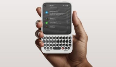 Clicks Communicator phone in a man's hand showing its screen and physical keyboard