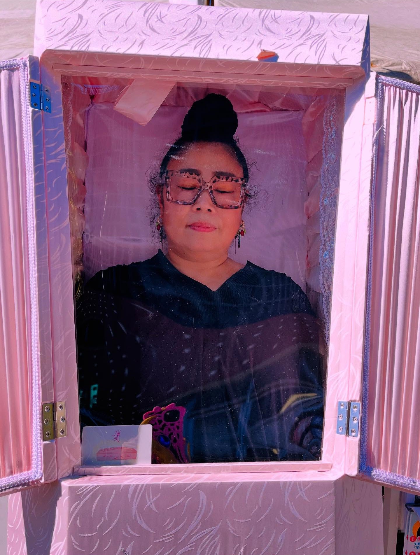 Mikako Fuse lying in a pink coffin.