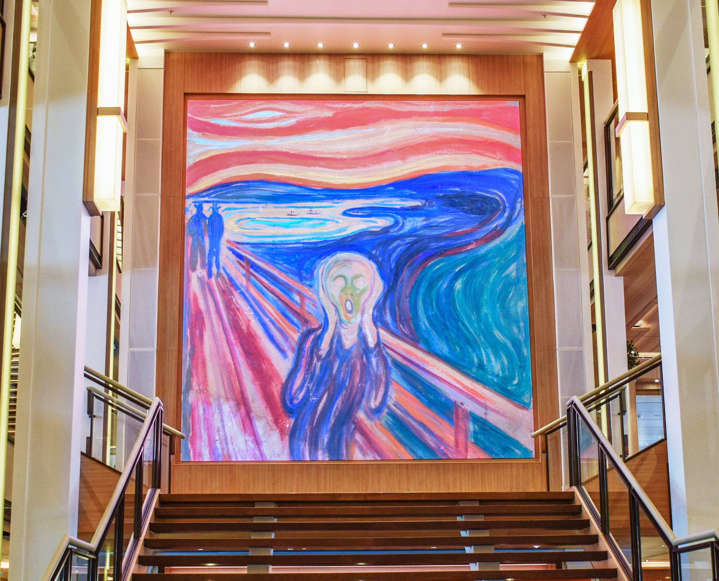 "The Scream" painting by Edvard Munch displayed on a large screen above a wooden staircase on the Viking Sea cruise ship.