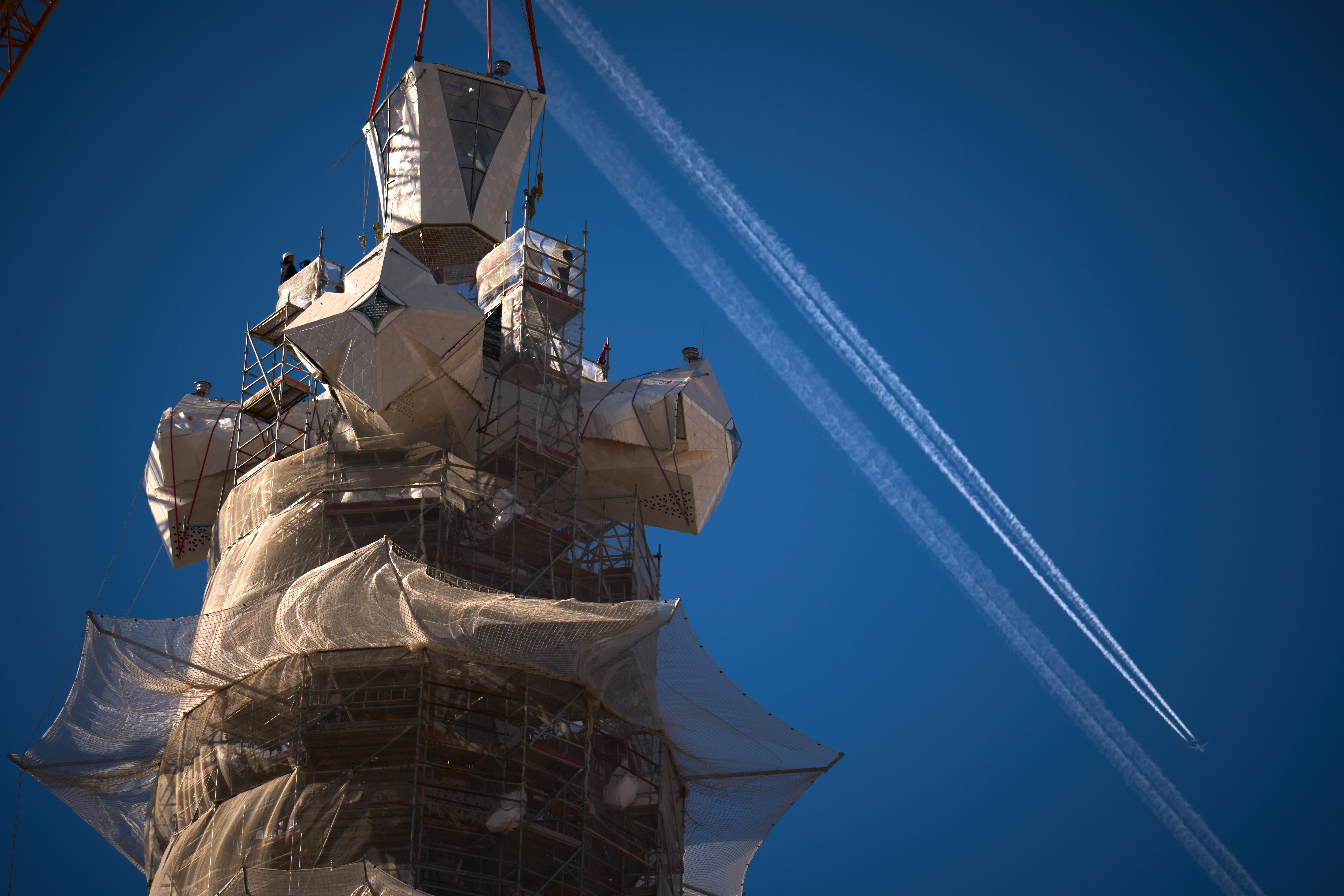A crane lifts the upper arm of a cross onto the Tower of Jesus Christ at the Sagrada Familia in Barcelona, Spain.