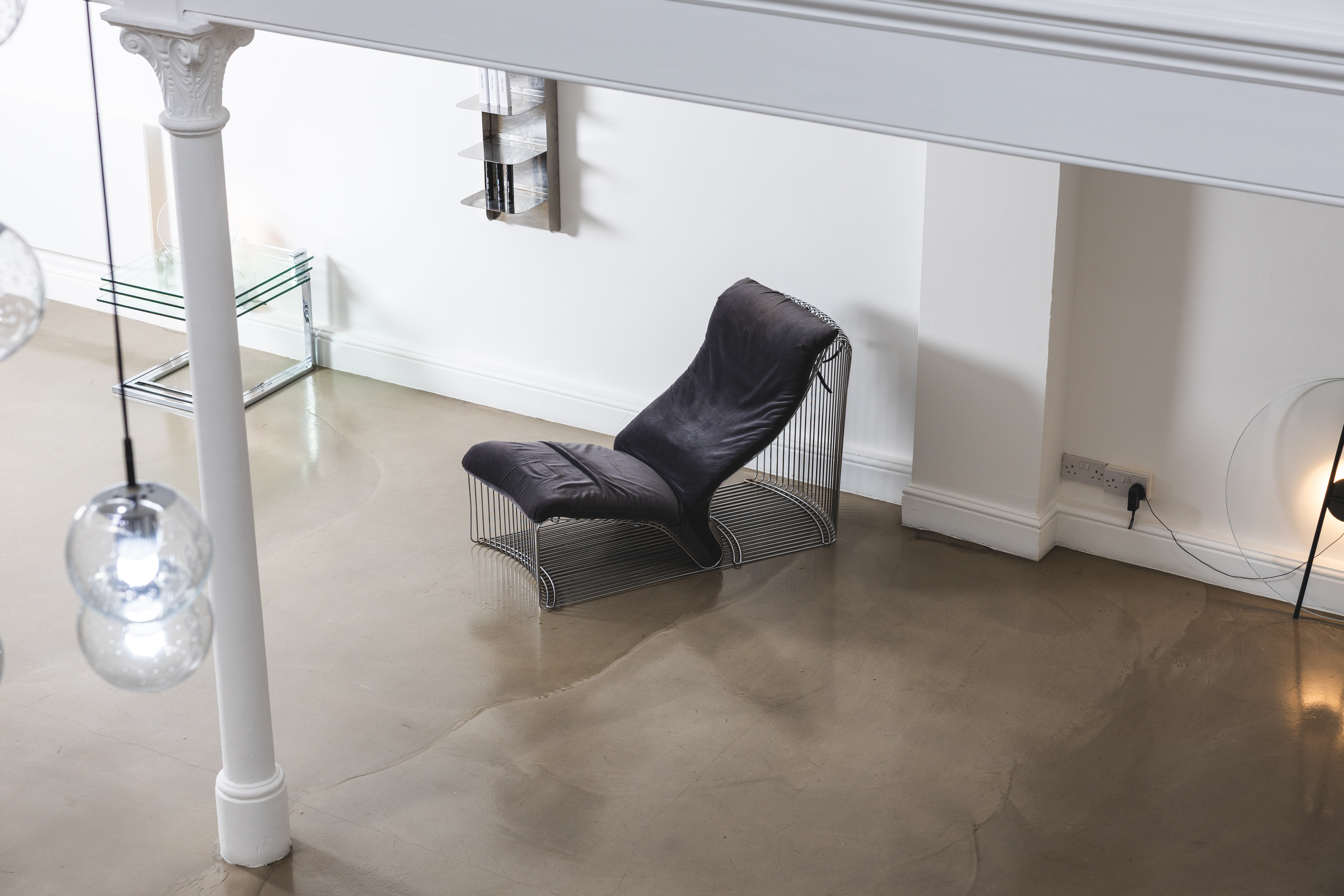 Interior of a modern skin clinic with a black lounge chair on a concrete floor.