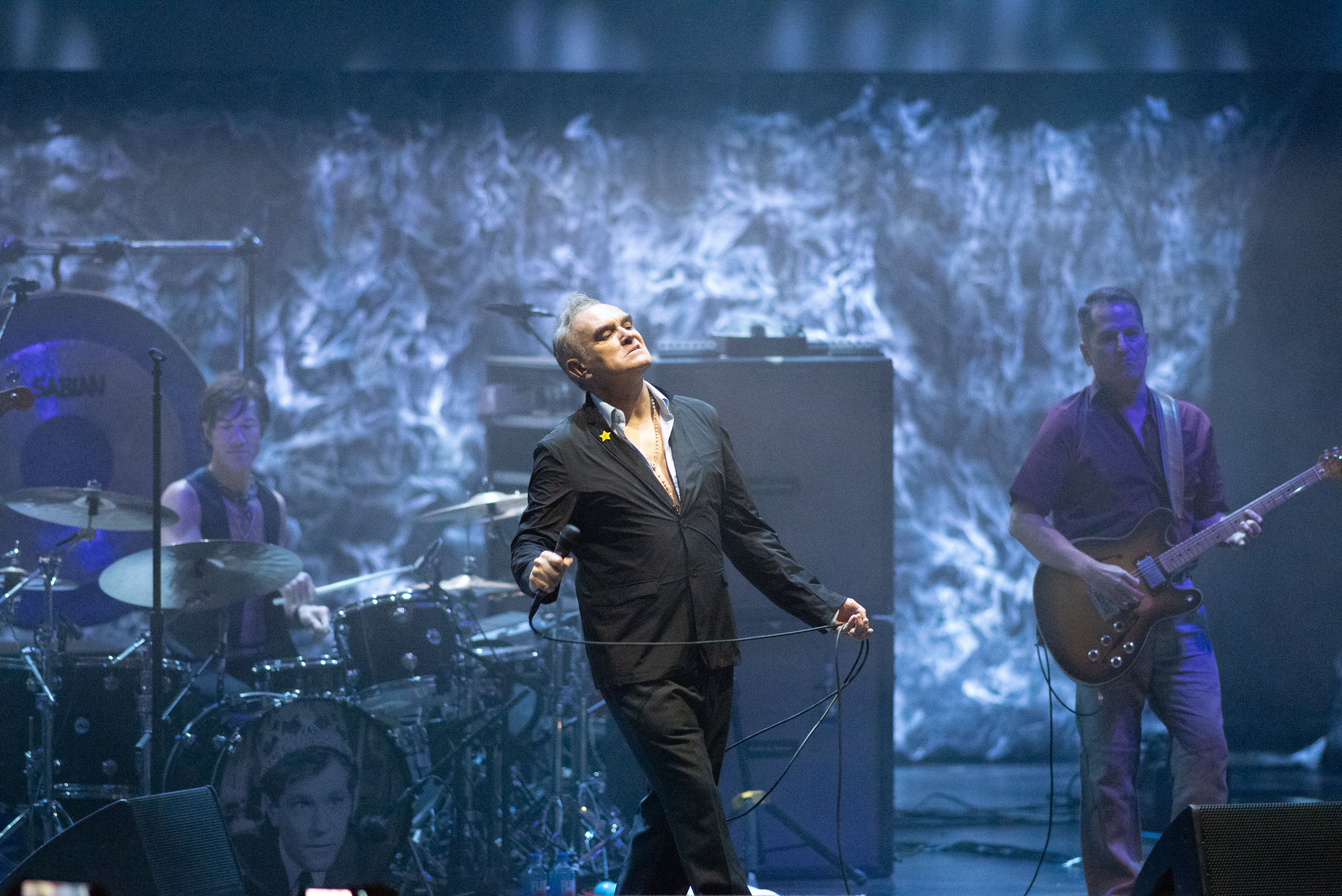 Morrissey performs on stage with his band.