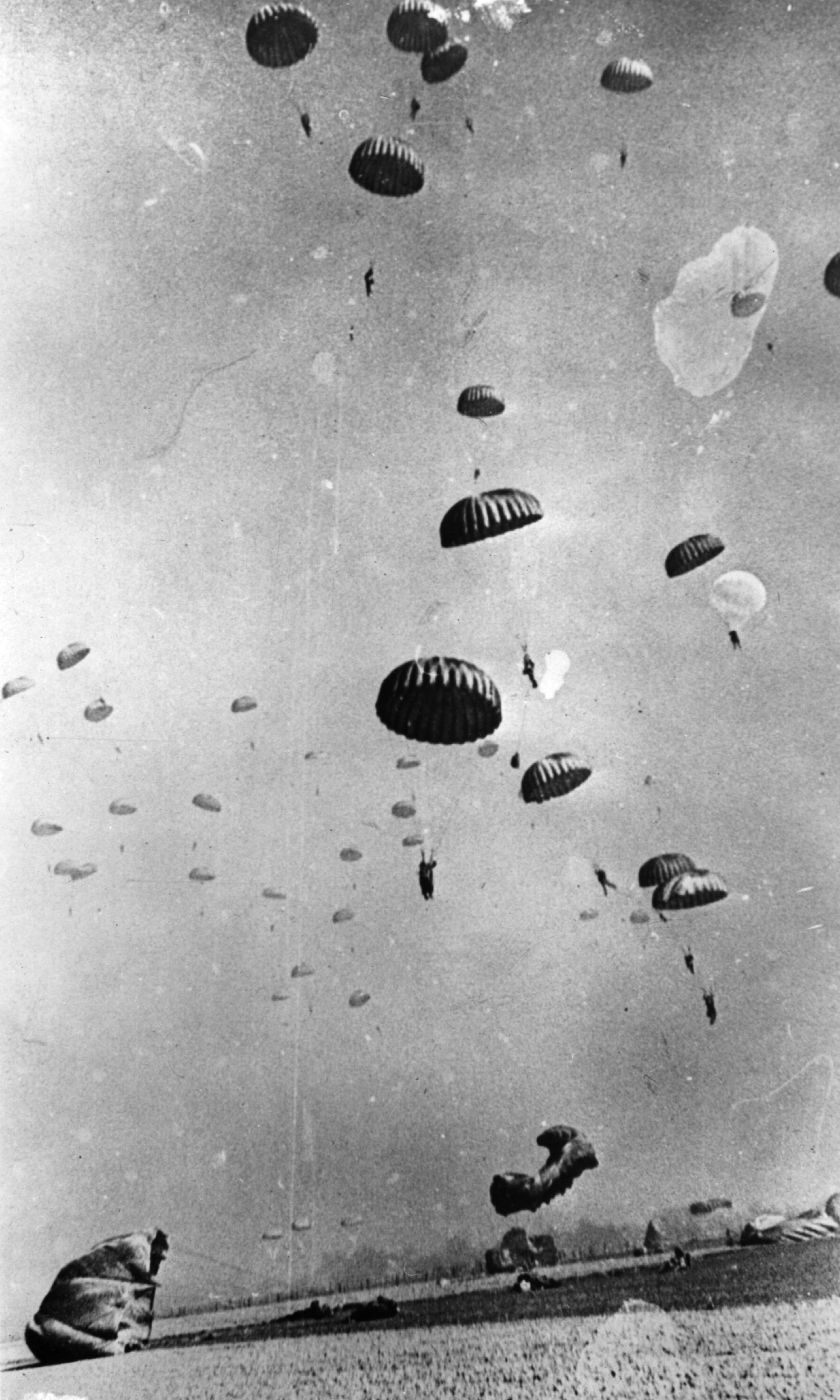 Black and white photo of paratroopers descending to secure the Rhine crossing during World War II.