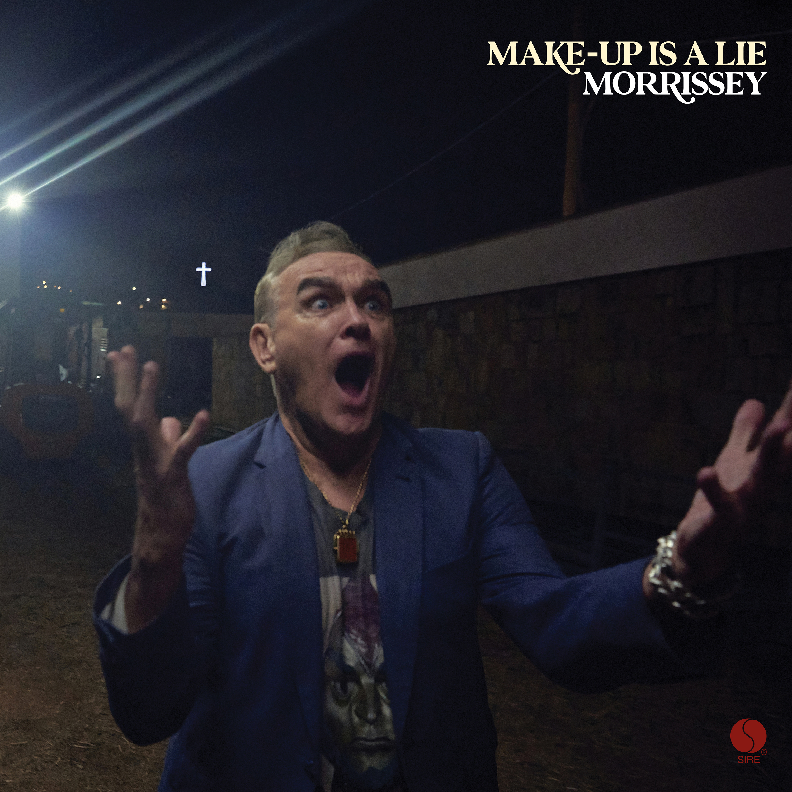 Morrissey with an open mouth and raised hands, looking shocked, with the text "MAKE-UP IS A LIE MORRISSEY" above him.