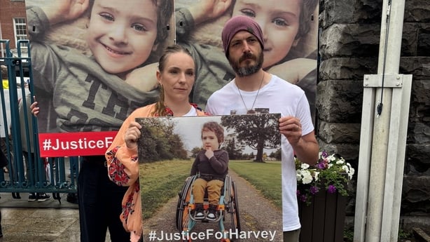 Stephen Morrison and Gillian Sherratt holding a sign of their son Harvey