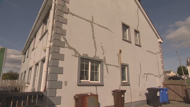 large cracks are visible on the exterior wall of a two-storey house