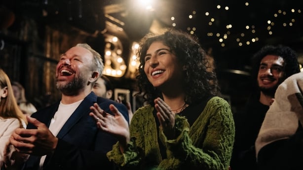 man and woman laughing at comedy show