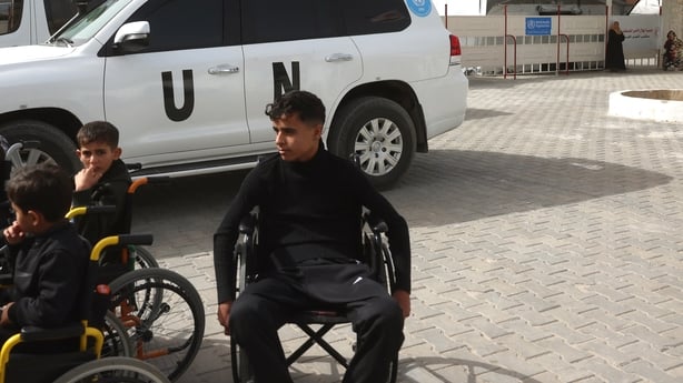 Young Palestinian patients sitting in wheelchairs wait in the grounds of the Red Crescent Hospital to be evacuated from Gaza