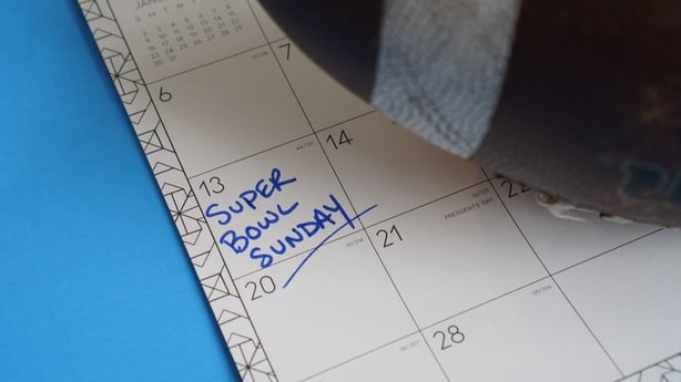 Super Bowl Sunday written on a calendar on February 13 (2022) along side a football.