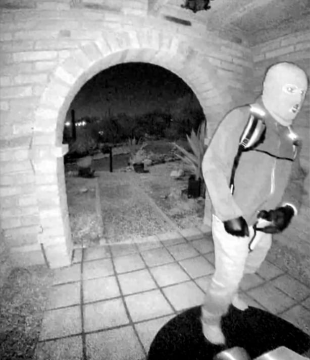 A masked man on a doorstep