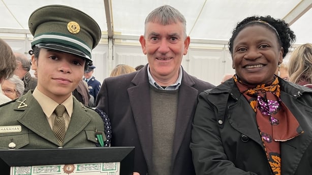 A photograph of a female soldier pictured with a smiling man and woman