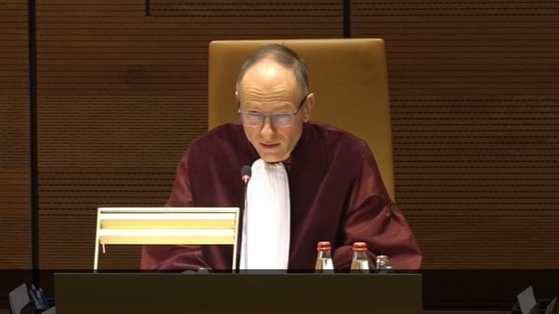 A judge sits in a court with judicial robes on