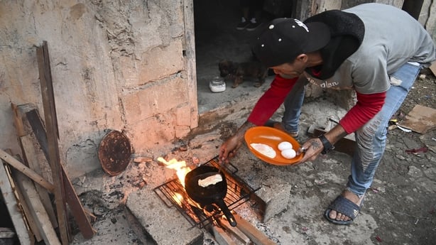 A man cooks eggs over a wood fire during a blackout in the Poey neighborhood of Havana 